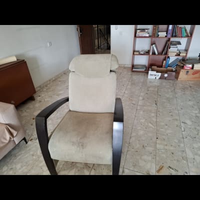 כיסא מרופד בחדר עם מדפים וספרים