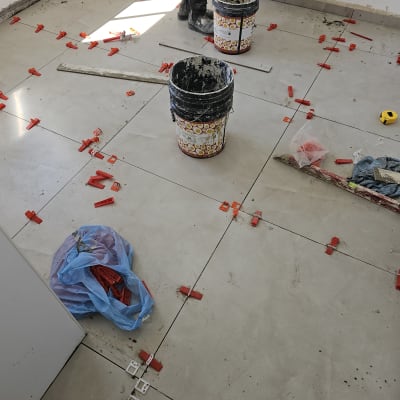 ריצוף קרמיקה עם דבק, דליים וכלי עבודה