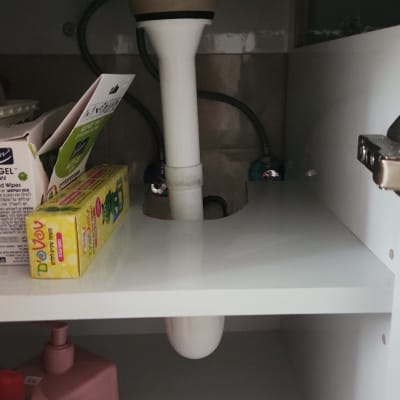צינור ניקוז לבן מתחת לכיור עם חיבורים