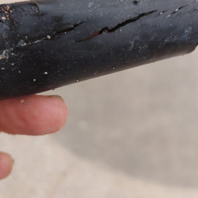 צינור שחור עם סדק מוחזק ביד