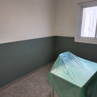 חדר צבוע עם קיר ירוק וחלון