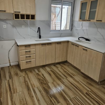 מטבח נקי עם ארונות עץ ורצפת פרקט מבריקה