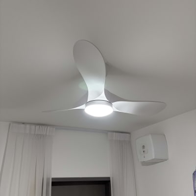 מאוורר תקרה עם תאורה בחדר עם וילונות לבנים