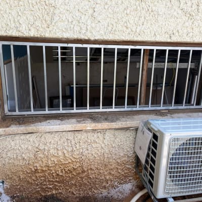 סורגי מתכת על חלון עם מסגרת עץ