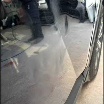 עובד מבצע פוליש על רכב במוסך