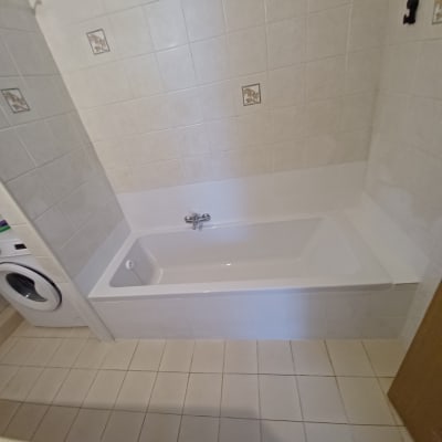 אמבטיה חדשה עם אריחים לבנים על הקיר