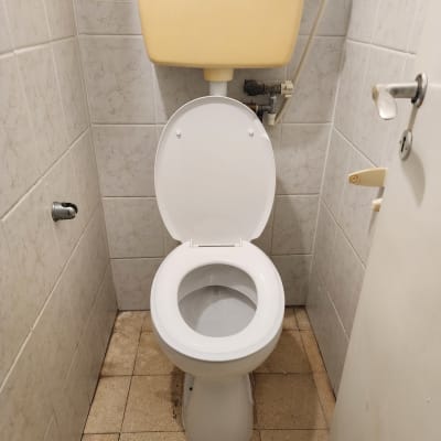 אסלה עם מיכל הדחה צהוב וצינור חיבור