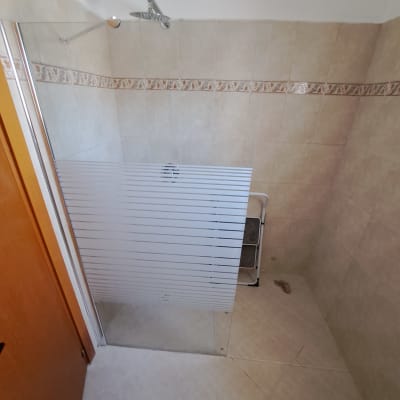 מקלחון עם דלת זכוכית וראש מקלחת