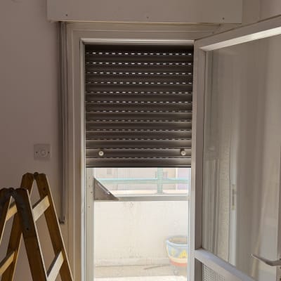 תריסים סגורים ליד דלת זכוכית ומדרגות עץ