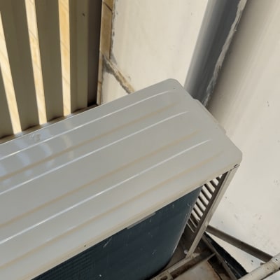 יחידת מזגן חיצונית עם צינור ומעט לכלוך