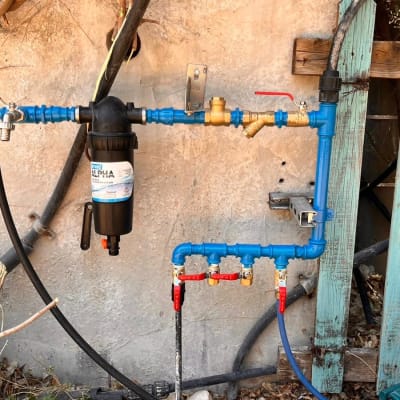 צנרת מים עם ברזים וכלים ליד גדר עץ