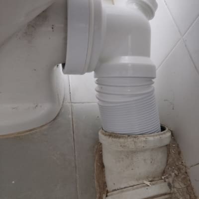 צינור פלסטיק לבן מחובר לאסלה