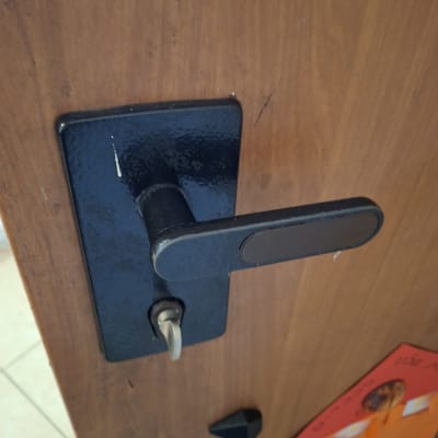 ידית דלת מתכתית על דלת עץ
