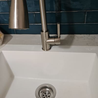 ברז נירוסטה וכיור לבן עם רקע אריחים כחולים