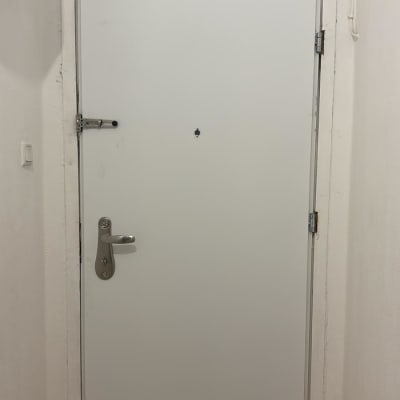 דלת לבנה עם ידית מתכת ובריח