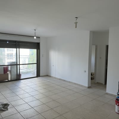 חדר ריק עם דלי צבע וכלי עבודה בפינה