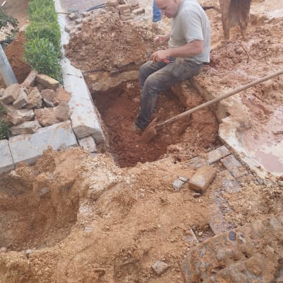 אדם חופר באדמה עם כלי עבודה