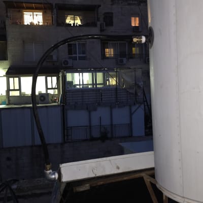 מיכל מים על גג עם צינור מחובר