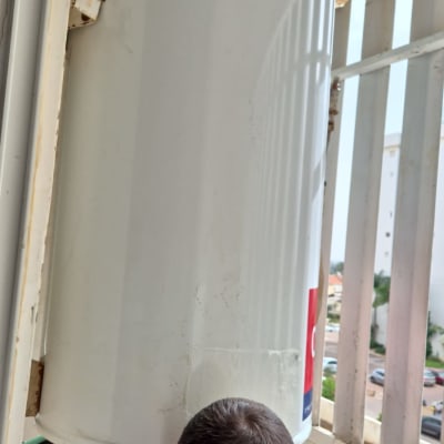 דוד שמש מותקן על מרפסת עם אדם עובד