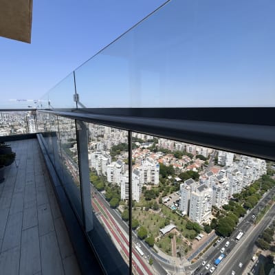 מרפסת עם נוף עירוני ומעקה זכוכית נקי