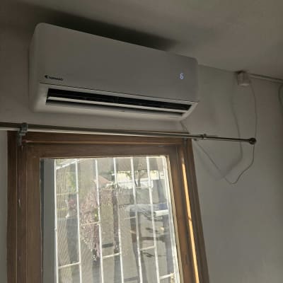 מזגן מותקן על קיר מעל חלון עם סורגים