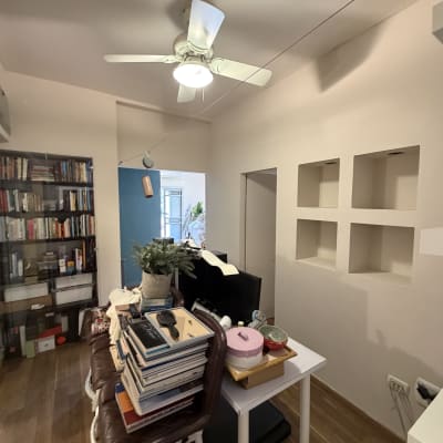 חדר עם מאוורר תקרה, מדפים וספרים