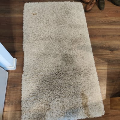 שטיח עם כתמים על רצפת עץ