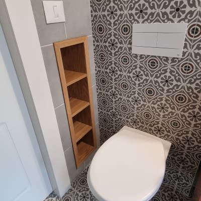 מדף עץ מובנה ליד אסלה בחדר אמבטיה מעוצב