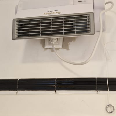 תנור חימום מותקן על קיר עם חיבור לחשמל