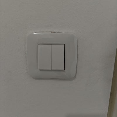 מתג חשמל כפול על קיר לבן
