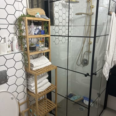 מקלחון זכוכית עם ראש מקלחת מוזהב ומוצרי רחצה