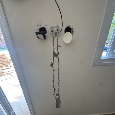 שקעי חשמל פתוחים עם חוטים וקיר שבור