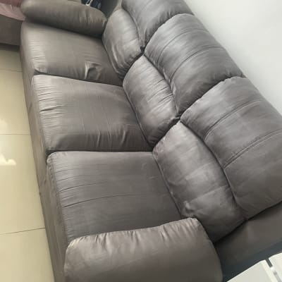 ספה אפורה בחדר מואר ליד שולחן קטן