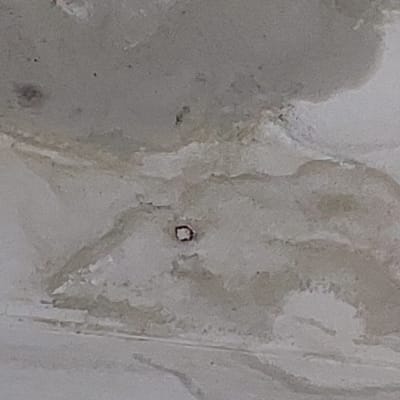 תקרה עם סימני רטיבות וצינור פלסטיק לבן