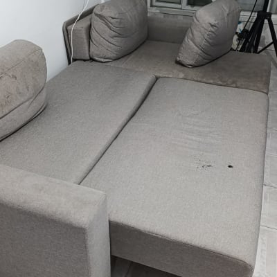 ספה אפורה עם כתמים קטנים על הרצפה