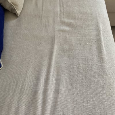 כרית ספה בהירה עם כתמים וקמטים