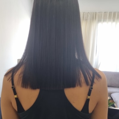 אישה עם שיער חלק ולבוש שחור