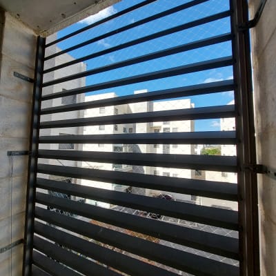 רשת מתכת על חלון למניעת כניסת יונים