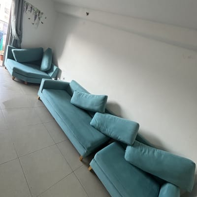 ספות כחולות מסודרות בחדר עם רצפת אריחים אפורה