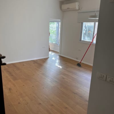 רצפת פרקט חדשה בחדר ריק עם מטאטא