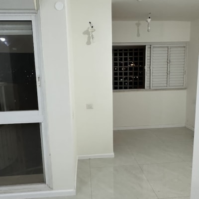 חדר עם רצפת קרמיקה, קירות צבועים ונורות חשופות