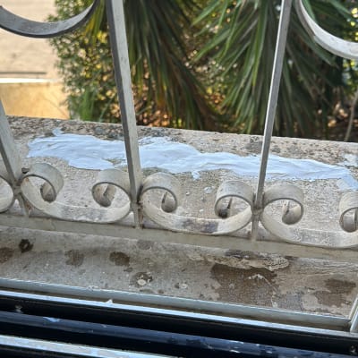 חומר איטום לבן על אדן חלון מתכת