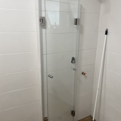 דלת זכוכית למקלחת עם מגב על הרצפה