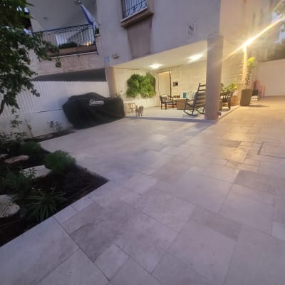רצפת אבן מרוצפת עם ריהוט גן ותאורה חיצונית
