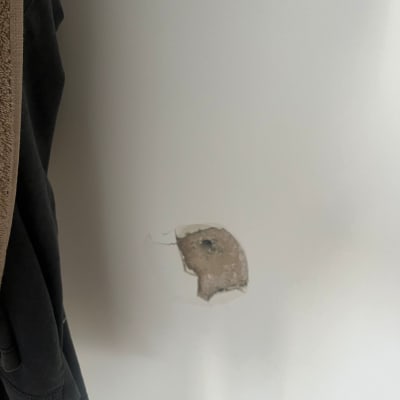 חור בקיר לבן עם טיח מתקלף