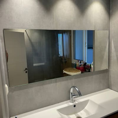 מראה גדולה מעל כיור בחדר אמבטיה