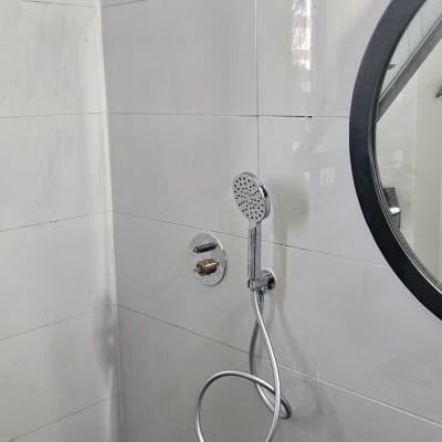 ראש מקלחת ומראה בחדר אמבטיה