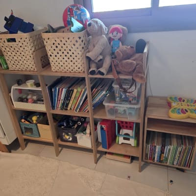 מדף עם צעצועים, ספרים וסלסלות לארגון חדר ילדים.