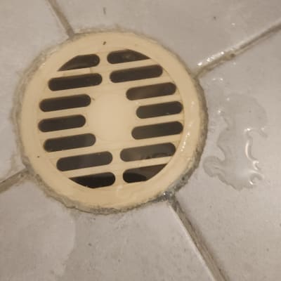 ניקוז מים על רצפת אריחים עם סימני רטיבות