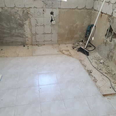 חדר בשיפוץ עם קירות חשופים וכלים לניקוי